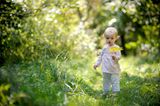 Baby in der Natur mit Blatt in der Hand