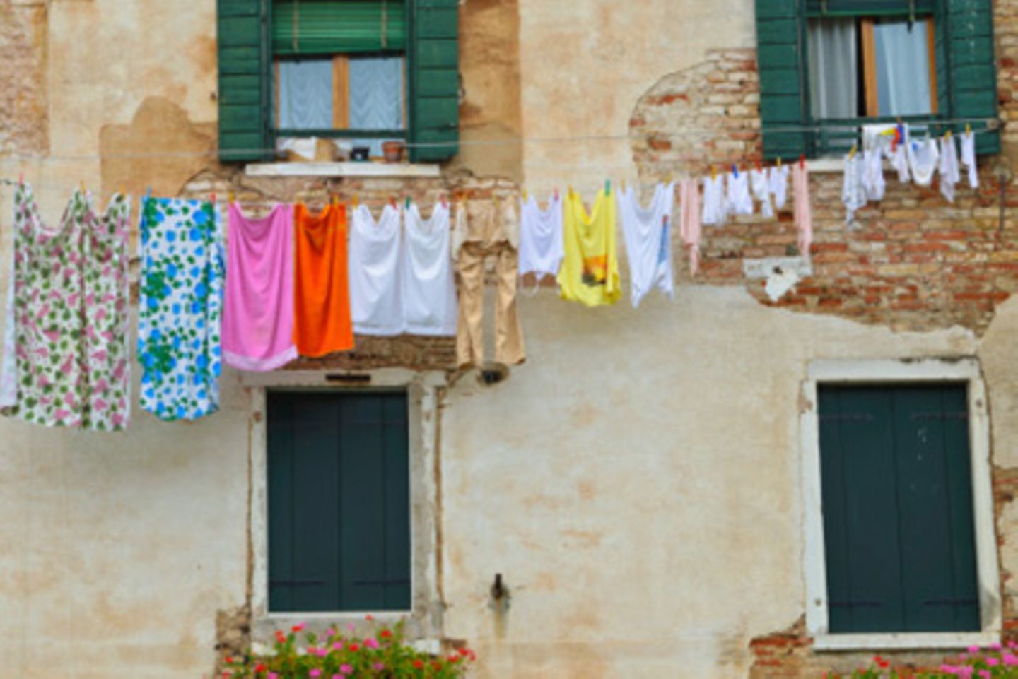 Wäscheleine mit Kleidung vor Hauswand