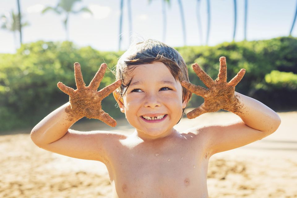 Kind spielt im Sand