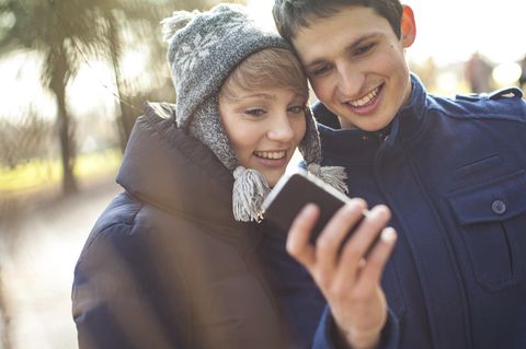 Jugendliche schauen auf ein Handy