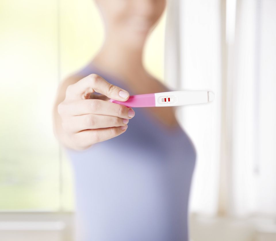 Frau hält positiven Schwangerschaftstest