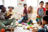 Kinder spielen mit Erwachsenen in einem Spielzimmer