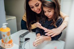 Mutter und Tochter waschen sich am Waschbecken die Hände