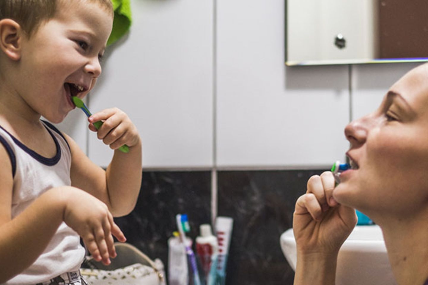 Kleiner Junge putzt sich mit Mama die Zähne
