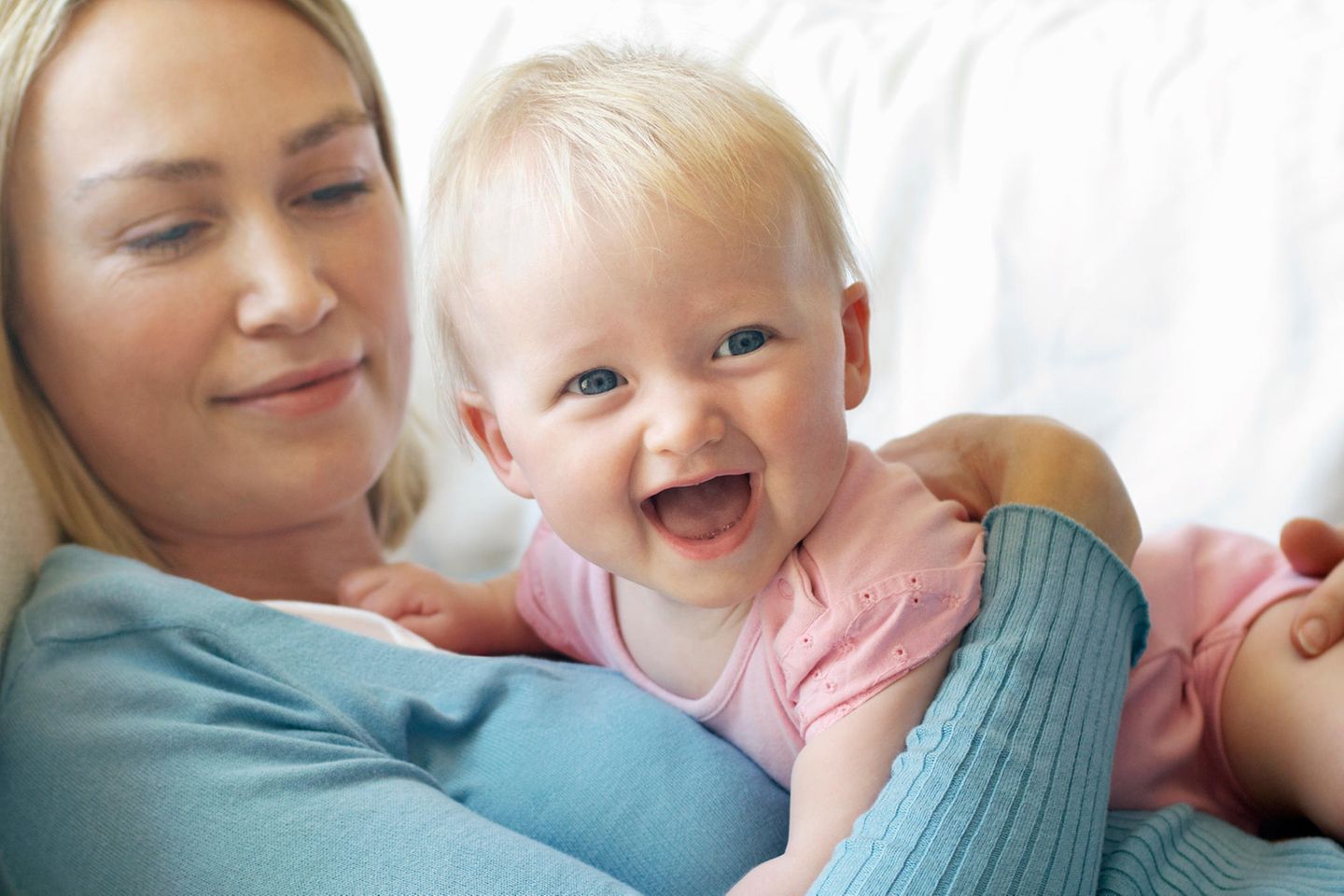 Mutter hat Baby auf dem Arm, liegen auf der Couch