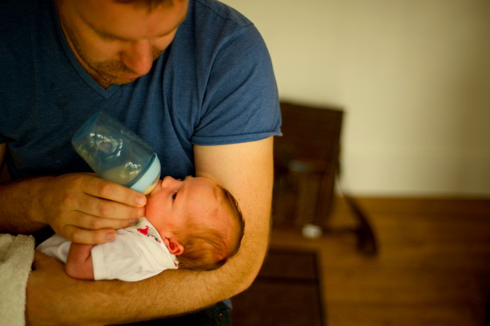 Vater füttert Baby mit Flasche
