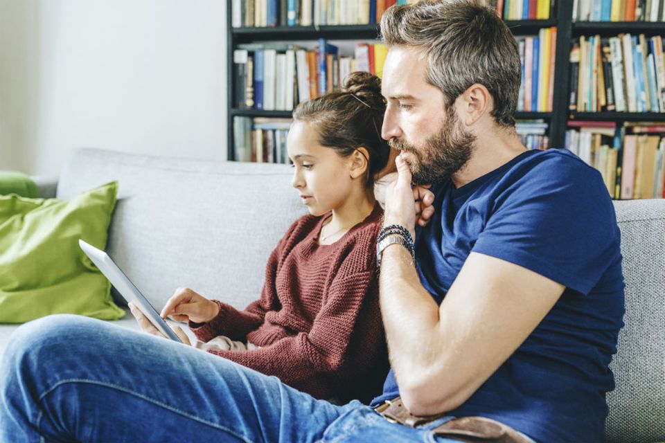 Vater und Tochter schauen auf ein Tablet Vater und Tochter schauen auf ein Tablet