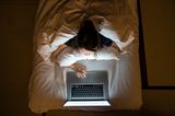 Frau im Bett mit Laptop