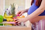 Schwangere schneidet Obst