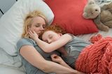 Mutter und Tochter kuscheln im Bett