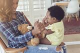 Beschäftigungsideen für dein Baby: Baby sitzt auf dem Schoß einer Frau