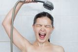 Frau unter der kalten Dusche