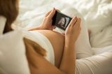 Frau betrachtet ein Ultraschall in 3D auf ihrem Handy