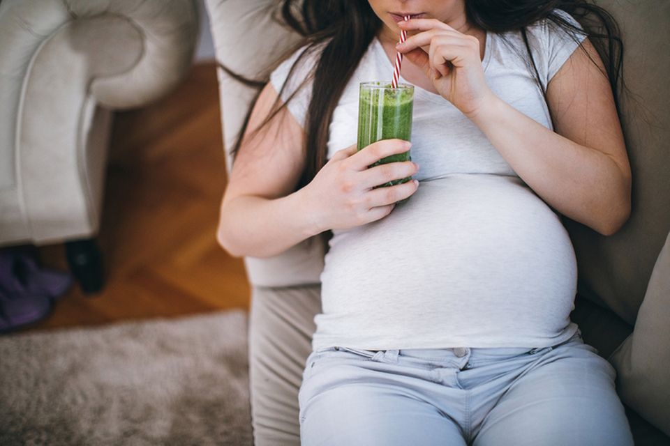 Schwangere Frau trinkt einen Smoothie