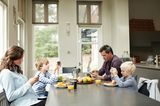 Fastenzeit: Familie sitzt am Esstisch, alle halten ein Smartphone in der Hand