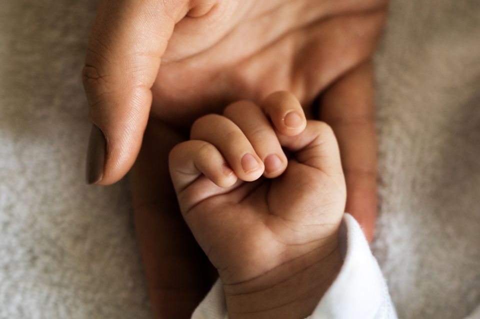 8. Wir haben ein ganz anderes Problem Mutter hält die Hand ihres Kindes.