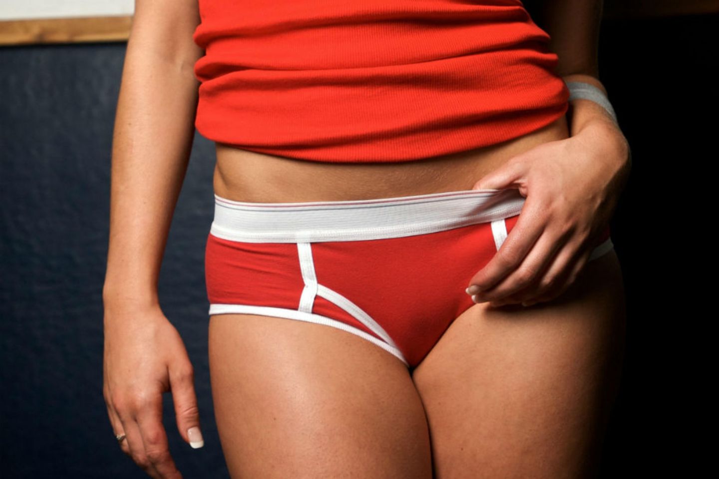 Ausfluss in der Schwangerschaft: Frau mit sportlicher, roter Unterwäsche
