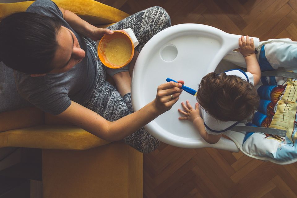 Beikostplan: Eine Mutter füttert ihrem Baby einen Brei