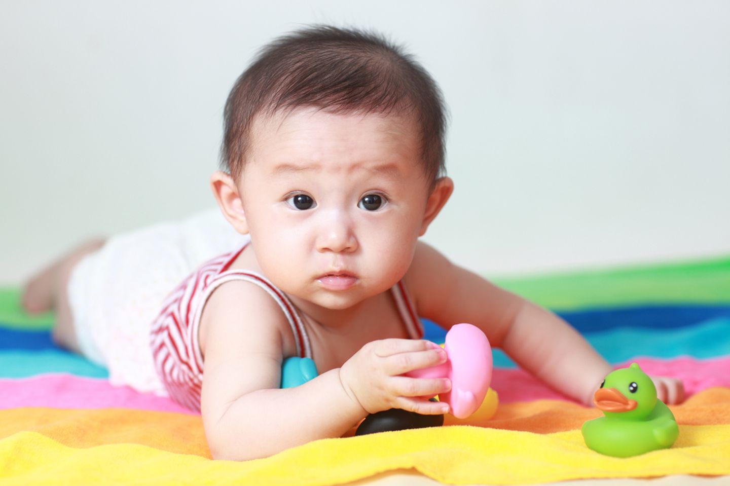 Baby liegt auf einer Krabbeldecke