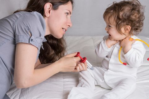 Frau und Kind spielen Impfen