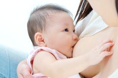Asiatisches Baby an der Brust