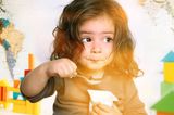 Mädchen isst einen Joghurt aus dem Becher