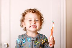 Leichter einschlafen: Gelocktes Kind mit Zahnlücke zeigt deine Zahnbürste.
