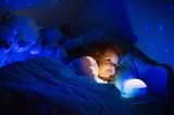 Leichter einschlafen: Ein Mädchen liegt im Bett und wird von einem Nachtlicht angeleuchtet.