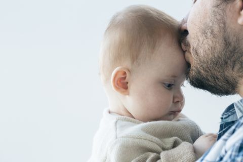 Vater küsst Baby auf die Stirn