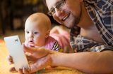 Vater und Baby liegen auf dem Boden