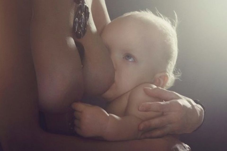 Baby spielt beim Stillen mit der Brustwarze
