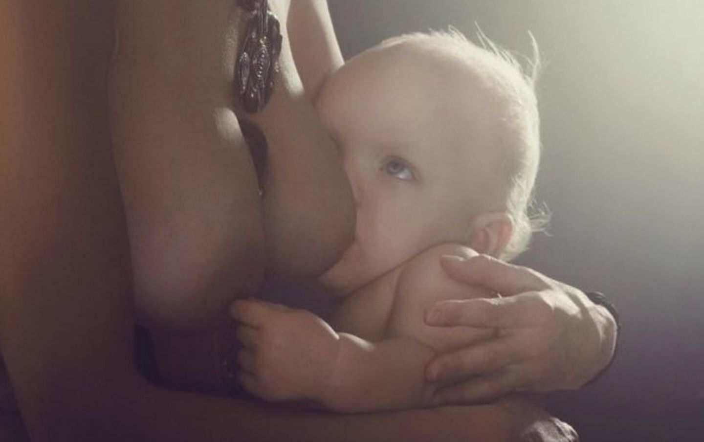 Baby spielt beim Stillen mit der Brustwarze Baby spielt beim Stillen mit der Brustwarze