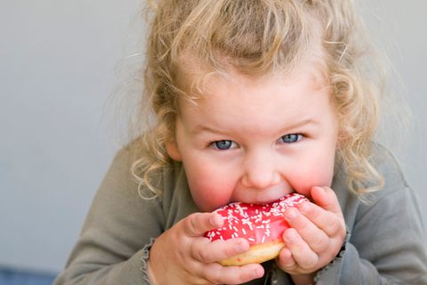 Mädchen beißt in einen Donut