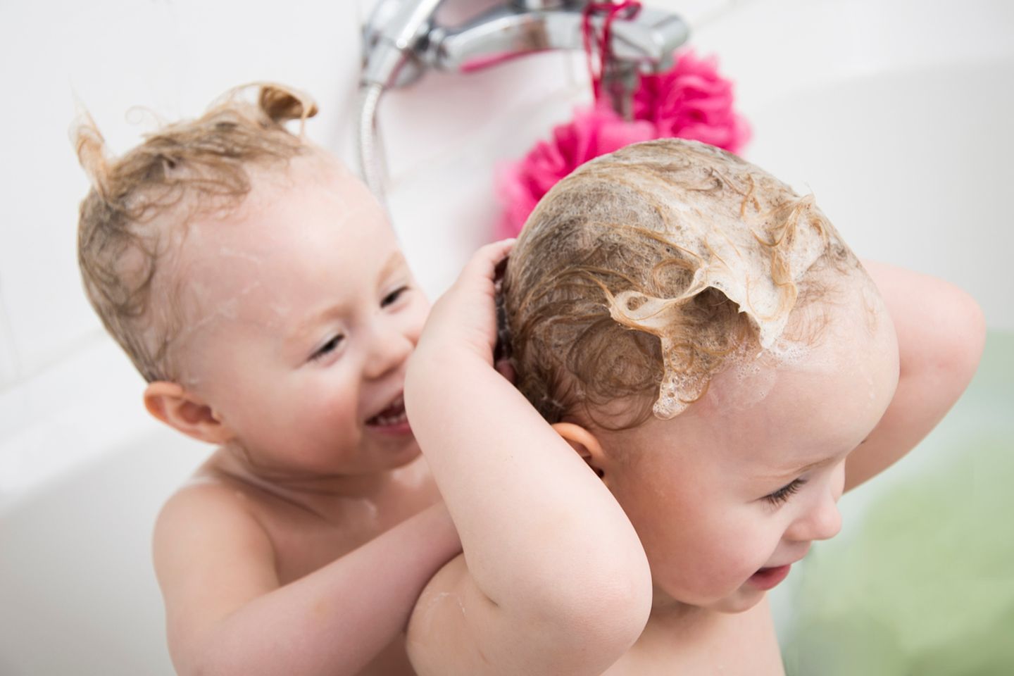 Zwei Kleinkinder waschen sich die Haare
