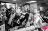 Familie begrüßt Baby durch die Glasscheibe