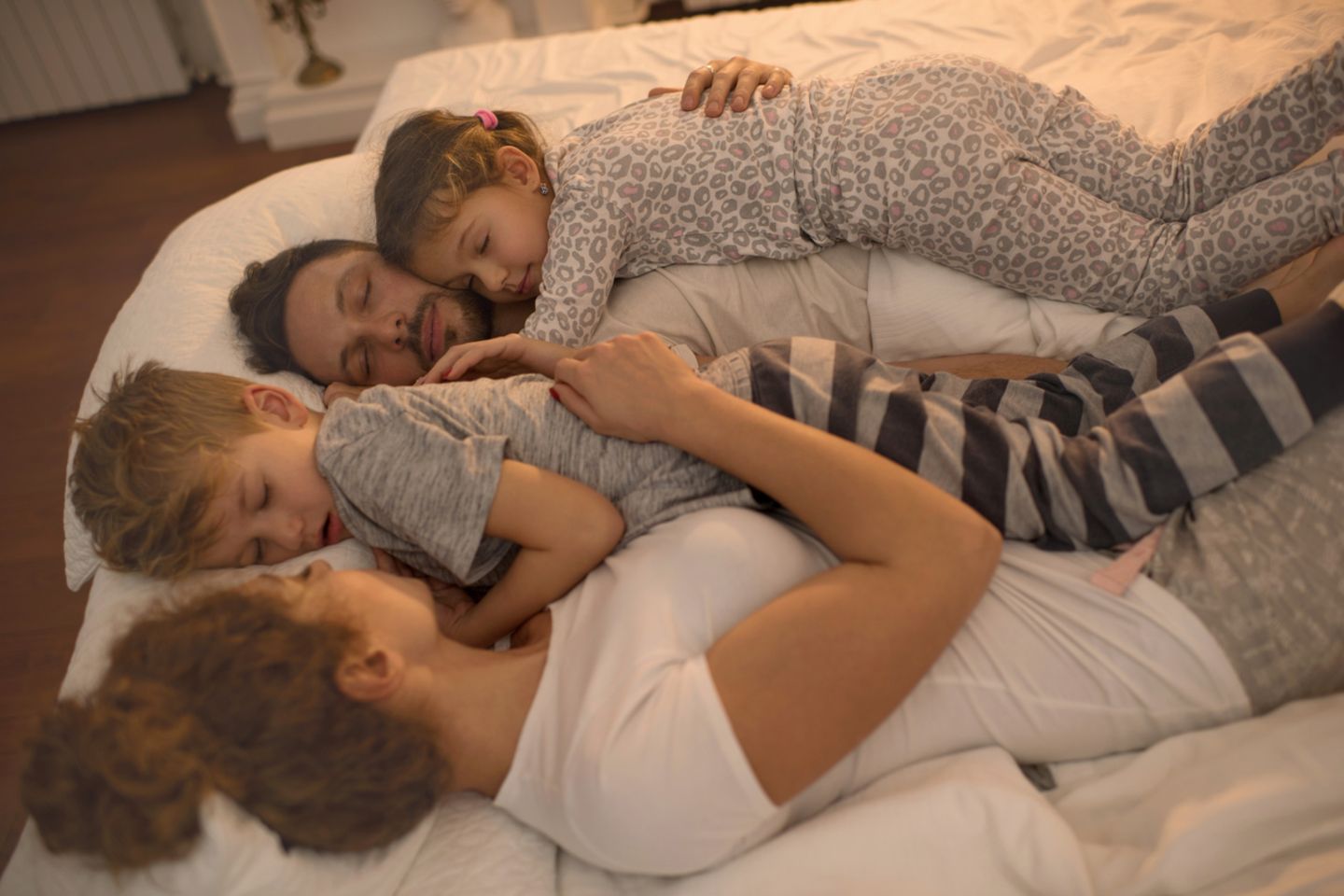 Familie schläft in einem Bett