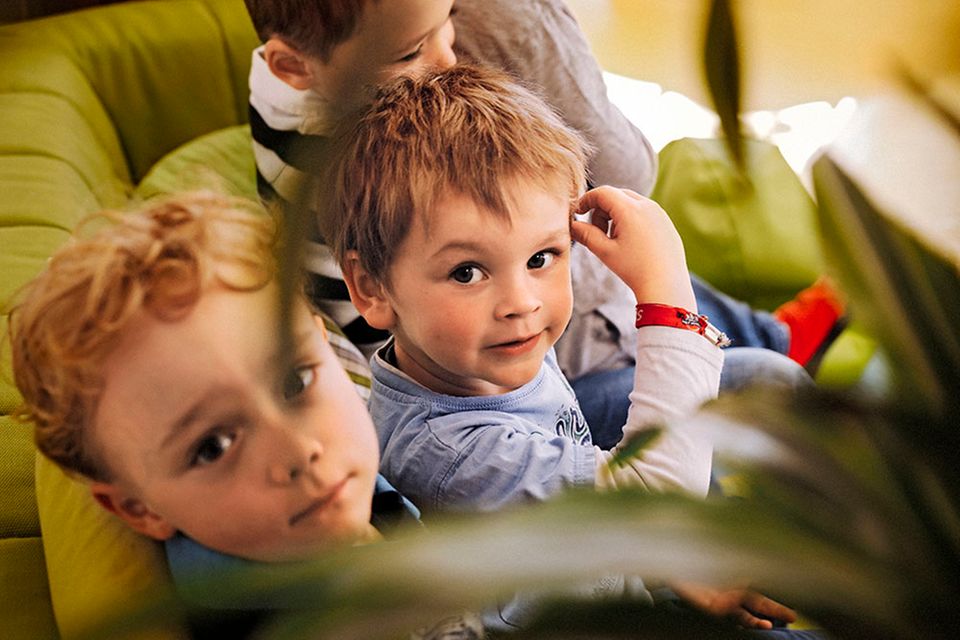 zwei kleine Jungs auf dem Sofa schauen in die Kamera
