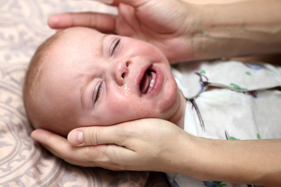 Erkältetes Baby weint auf dem Wickeltisch