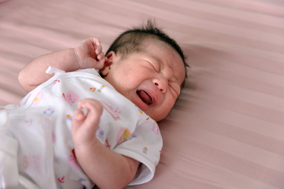 Asiatisches Neugeborenes schreit auf dem Wickeltisch