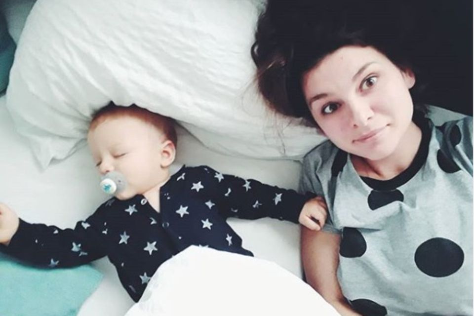 Mutter liegt neben schlafendem Baby Mutter liegt neben schlafendem Baby