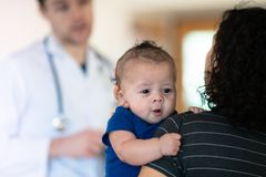 Weniger Stress beim Kinderarzt: Kleiner Junge auf Arm der Mutter beim Kinderarzt
