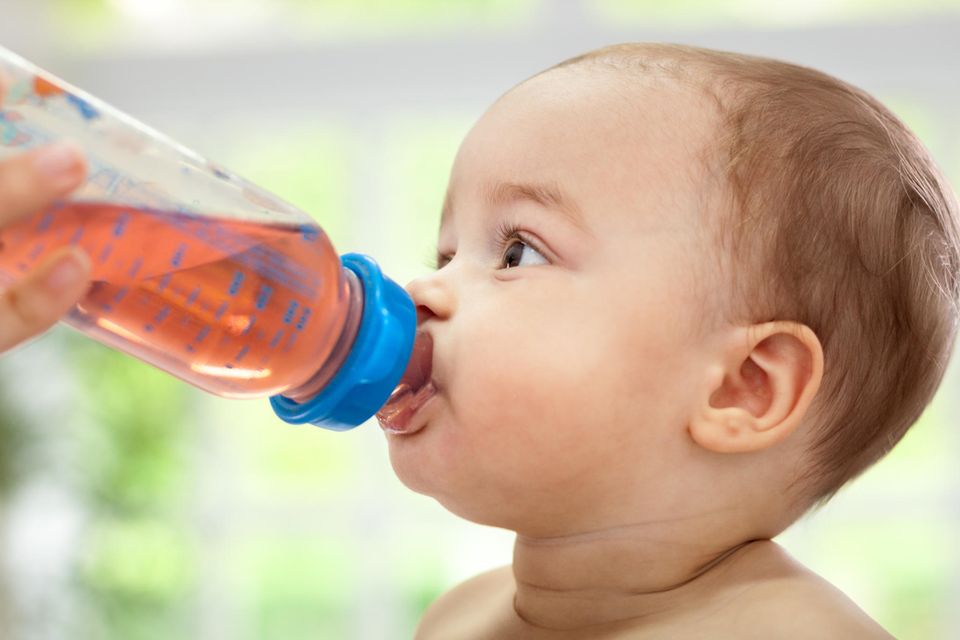 Babytee: Baby trinkt Tee aus der Babyflasche.