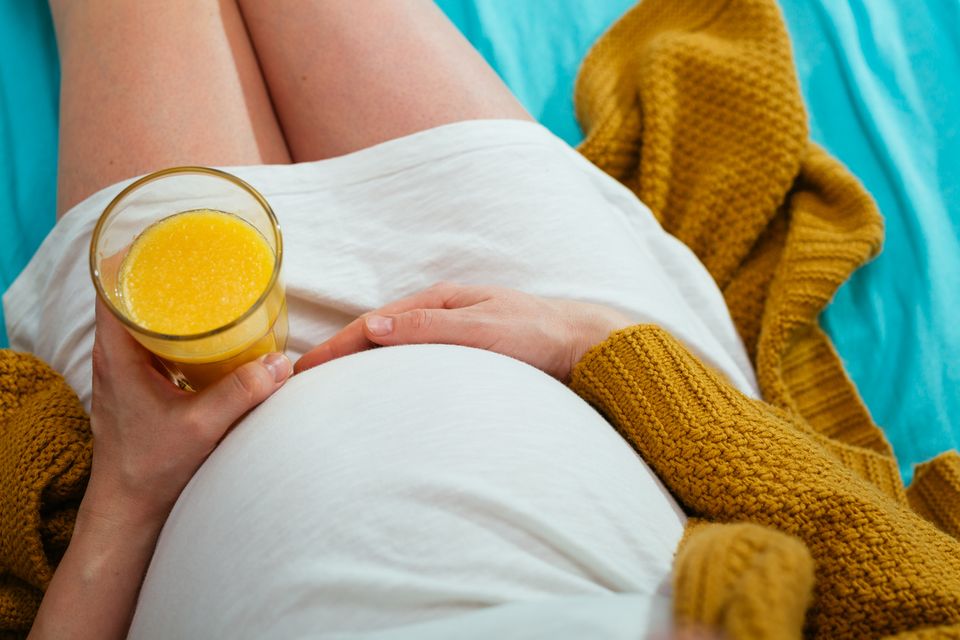 Schwangere trinkt ein Glas Orangensaft