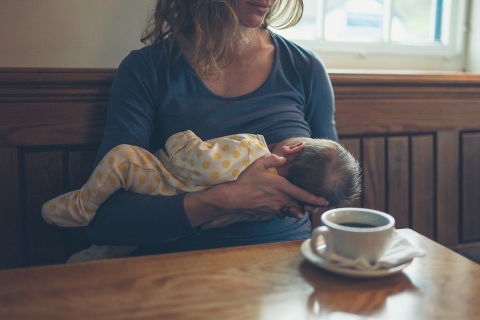 Mutter stillt Baby in Cafe