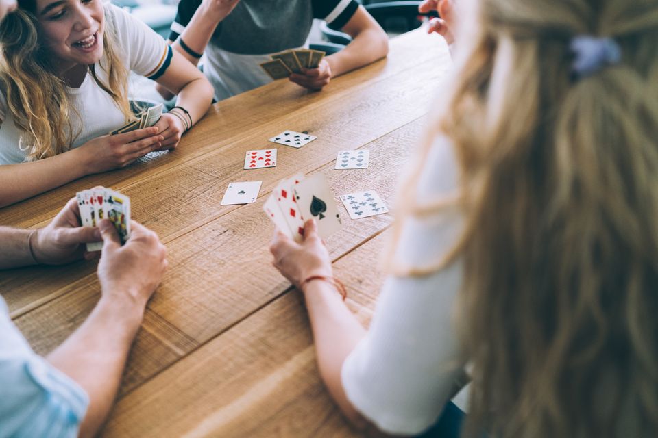 Eine Familie spielt ein Kartenspiel am Esstisch