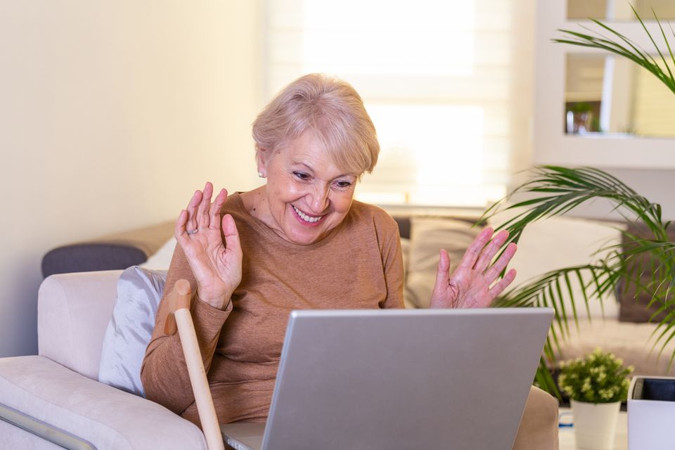Eine Oma freut sich mit ihren Enkeln über Video-Chat zu kommunizieren