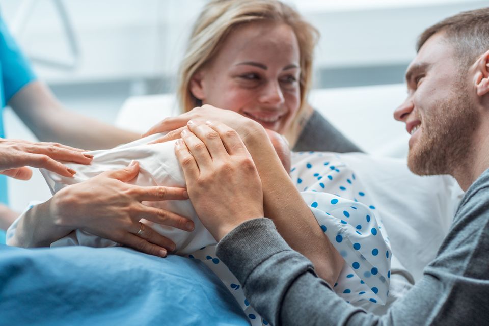 Vater, Mutter und Baby im Krankenhaus kurz nach der Entbindung