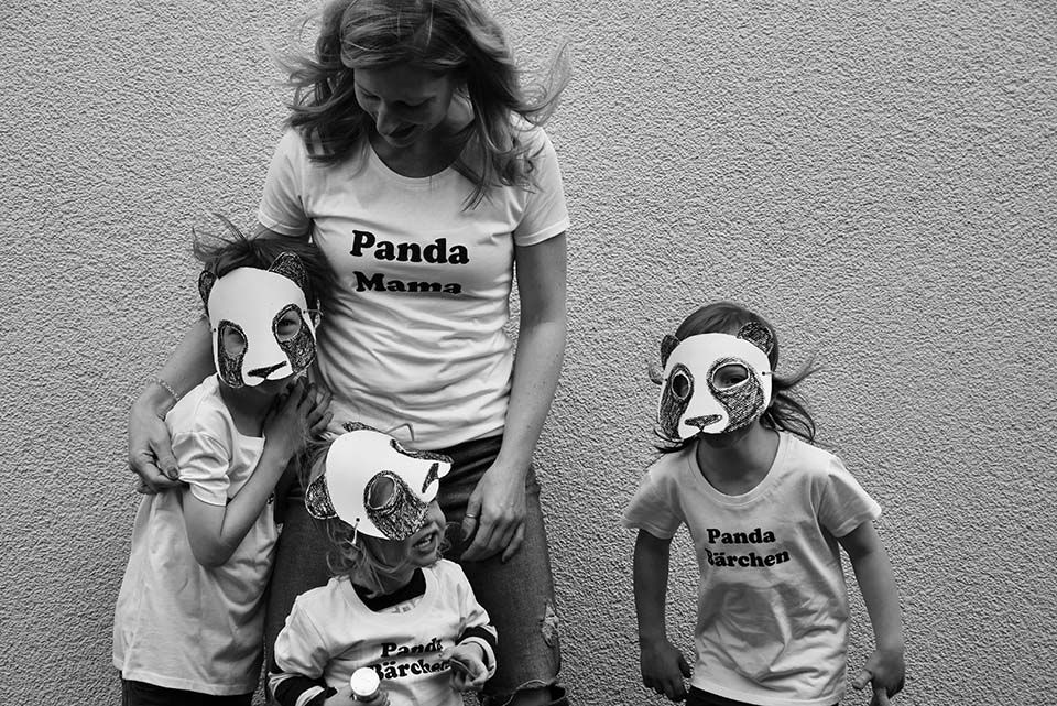 Laura mit ihren drei Kindern, die alle Masken tragen Laura mit ihren drei Kindern, die alle Masken tragen
