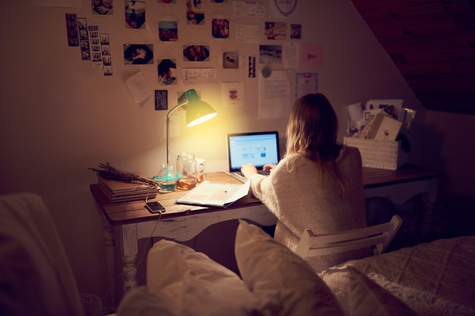 Frau sitzt nachts zuhause am Laptop