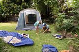 Vater und Sohn bauen Zelt im Garten auf